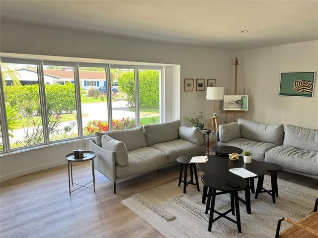 a living room with furniture wooden floor and a table