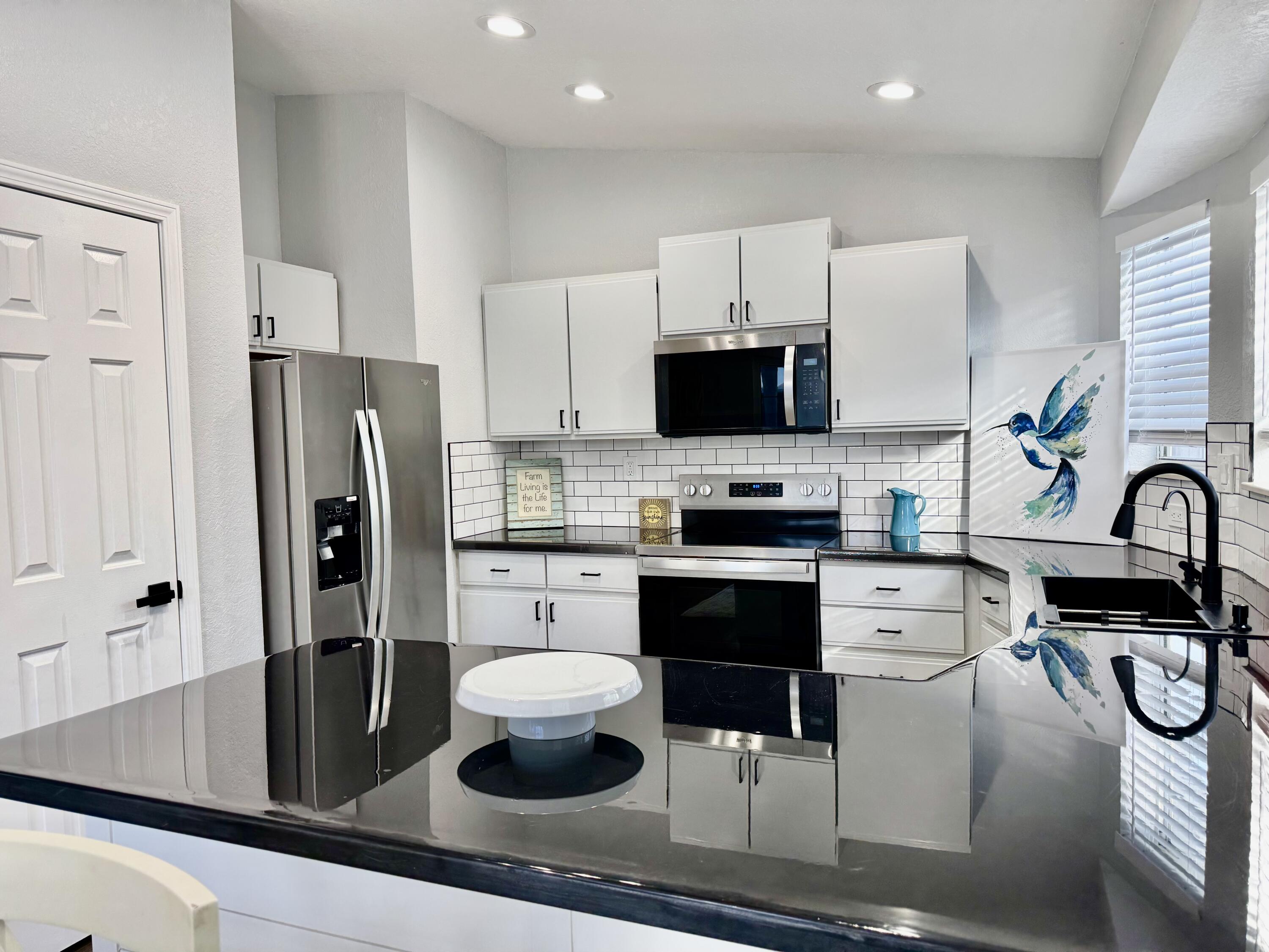 4350 Southwest 13th Avenue Okeechobee, FL 34974 - Photo 12 of 43 a kitchen with stainless steel appliances a refrigerator a stove a sink and white cabinets