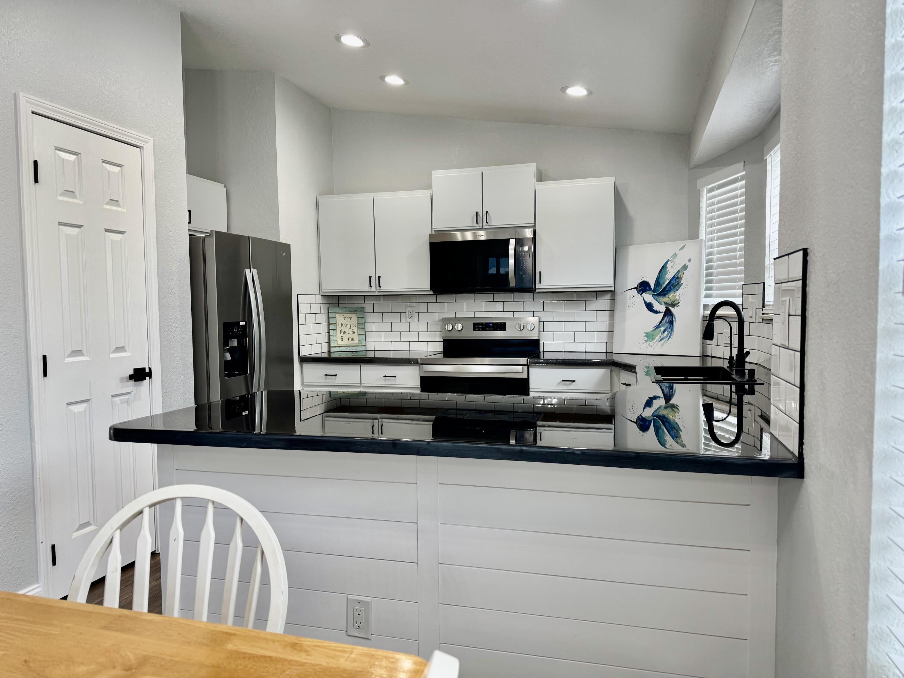 4350 Southwest 13th Avenue Okeechobee, FL 34974 - Photo 13 of 43 a kitchen with stainless steel appliances granite countertop a refrigerator and a stove top oven