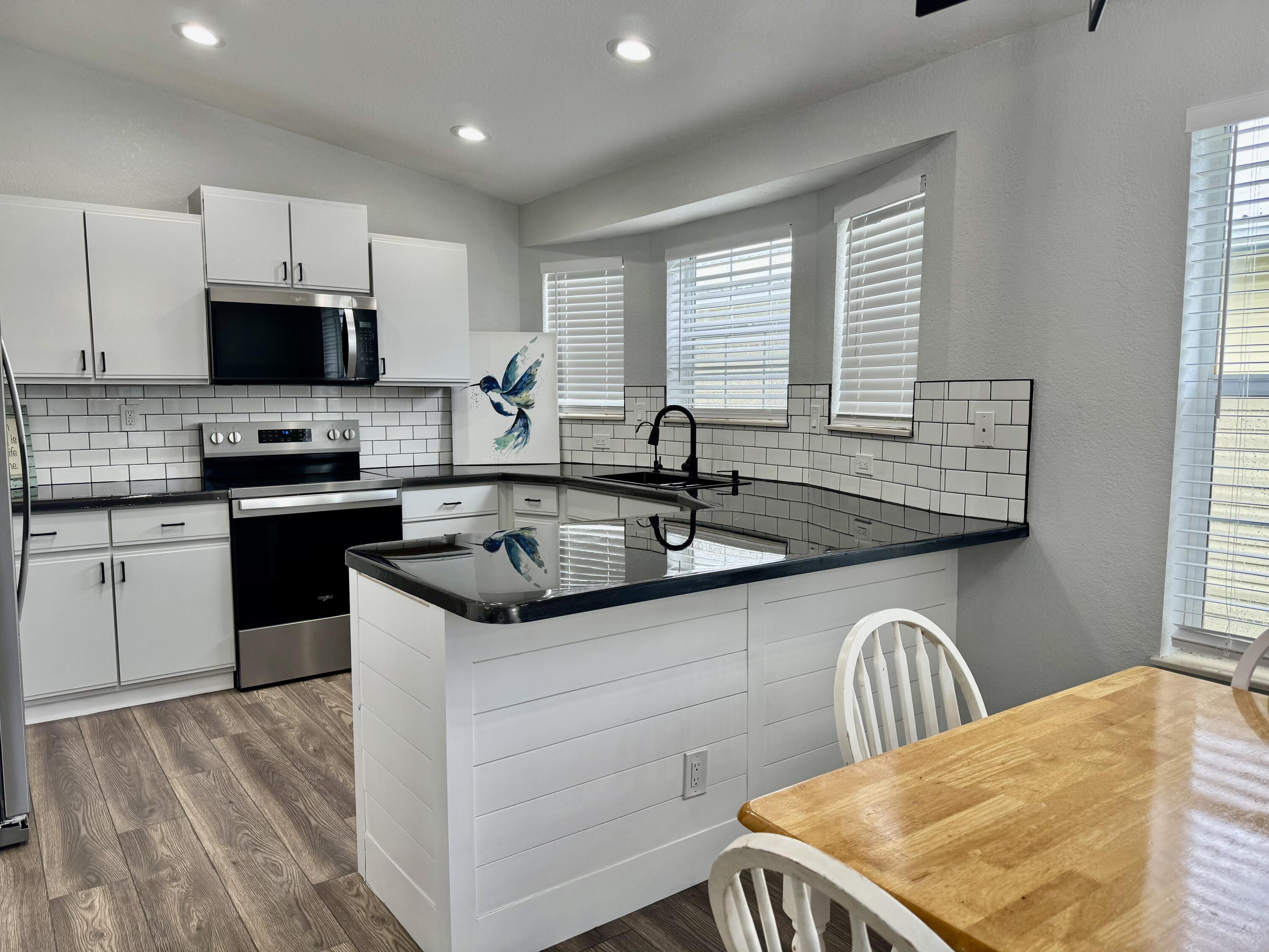 4350 Southwest 13th Avenue Okeechobee, FL 34974 - Photo 15 of 43 a kitchen with stainless steel appliances granite countertop a sink stove and microwave