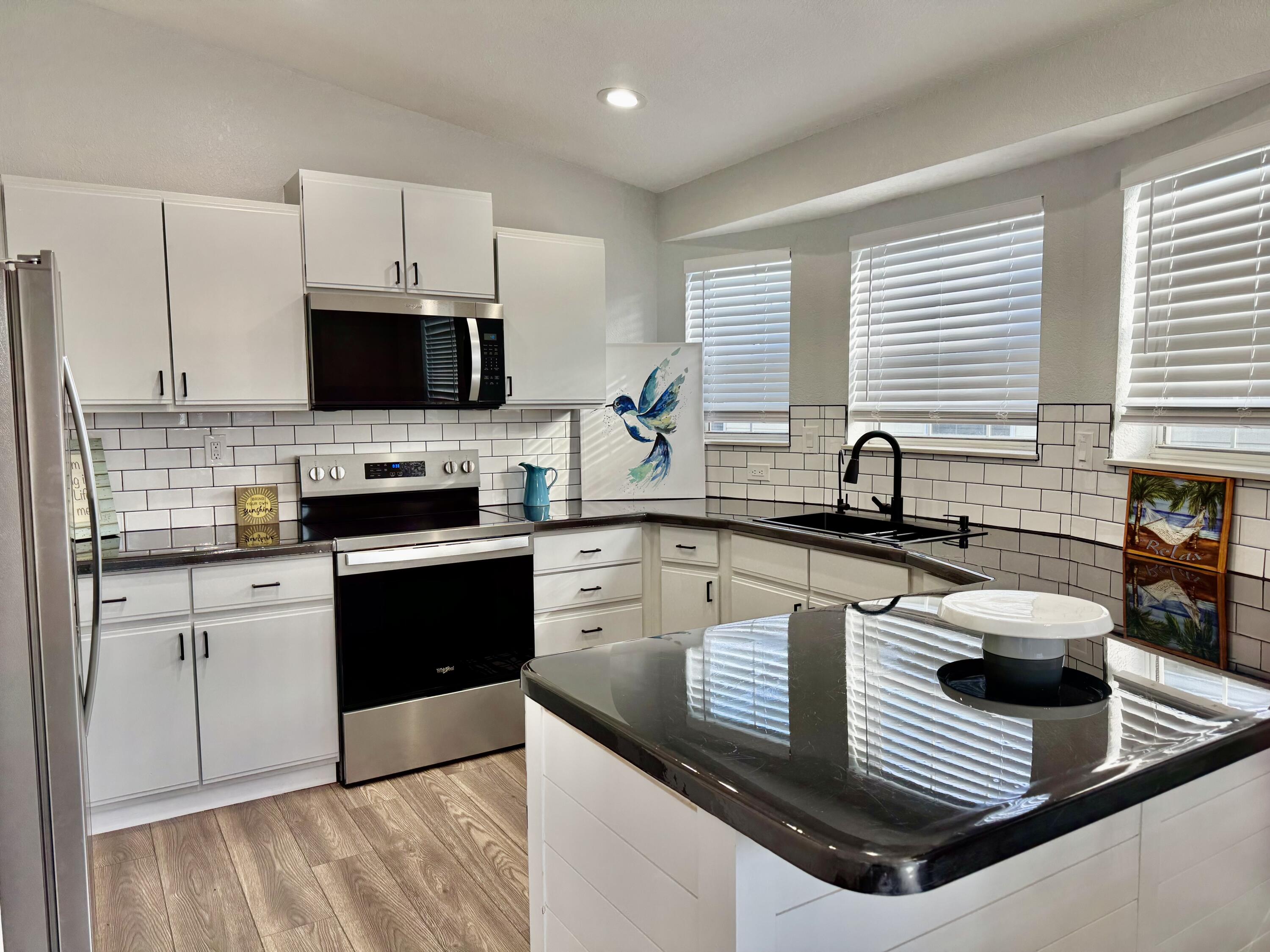 4350 Southwest 13th Avenue Okeechobee, FL 34974 - Photo 3 of 43 a kitchen with stainless steel appliances a sink a stove a microwave and cabinets