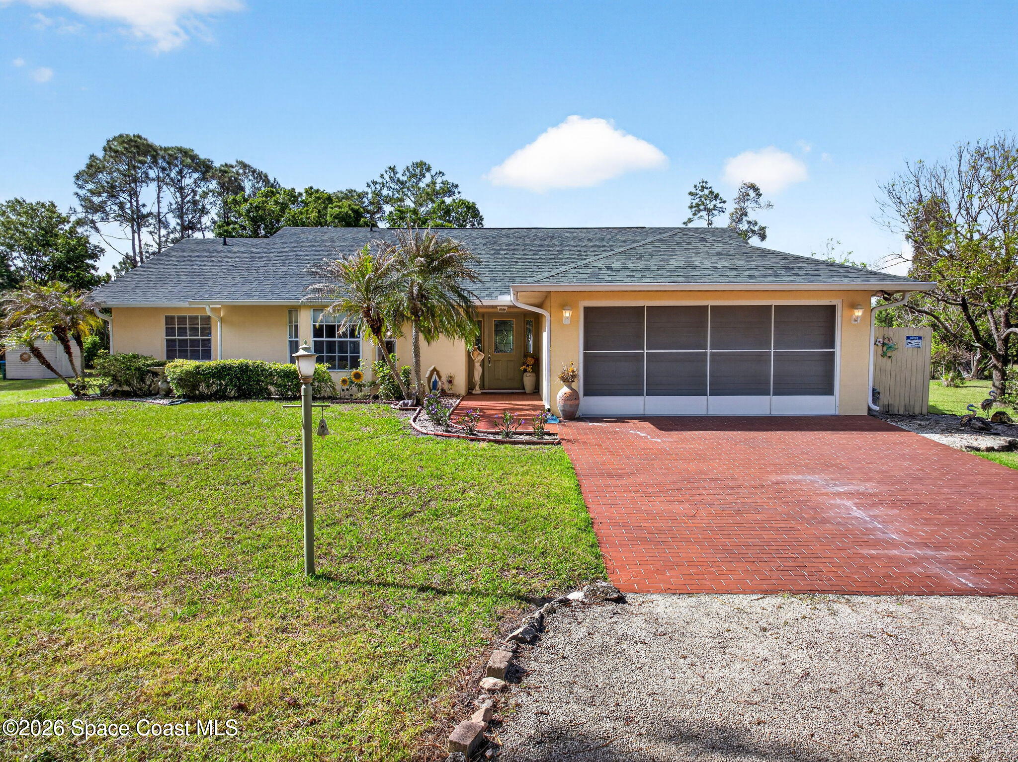 1455 Atz Road Malabar, FL 32950 - Photo 13 of 72 a front view of a house with a yard and potted plants