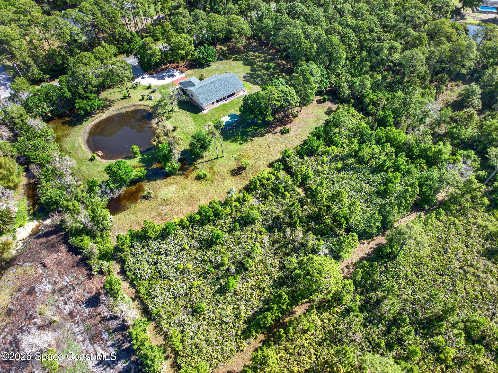 1455 Atz Road Malabar, FL 32950 - Photo 7 of 72 an aerial view of a house with a yard and large trees