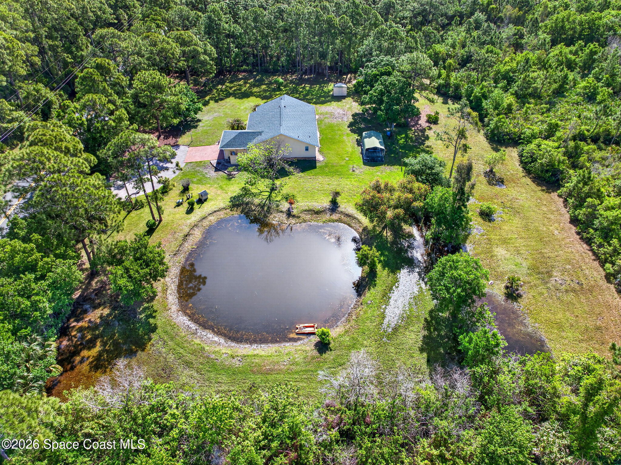 1455 Atz Road Malabar, FL 32950 - Photo 9 of 72 an aerial view of a house with a yard and trees all around