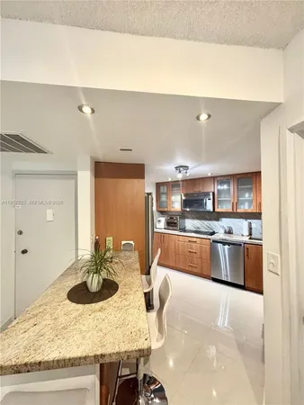 a kitchen with stainless steel appliances kitchen island granite countertop a table and chairs in it