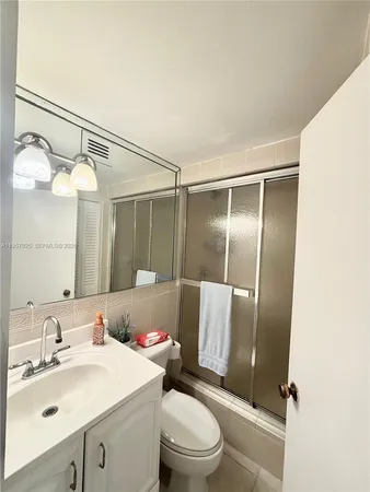 a bathroom with a sink vanity mirror and toilet