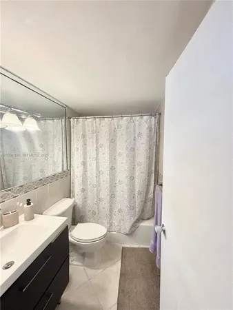 a bathroom with a granite countertop sink a toilet and shower