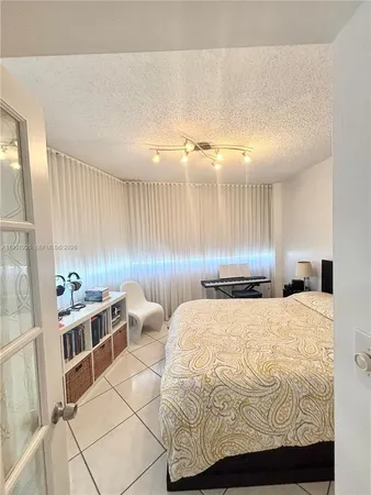 a large white room with a large bed and kitchen view