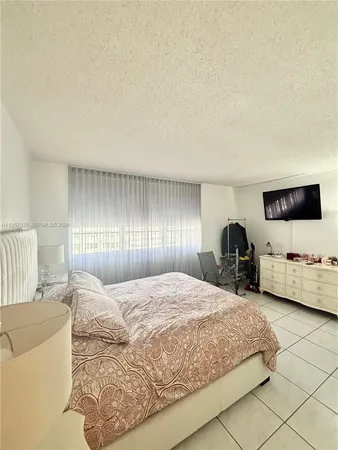 a bedroom with a bed large window and couch