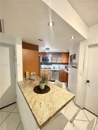 a kitchen with a sink a refrigerator and cabinets