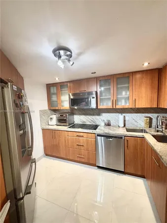 a large kitchen with stainless steel appliances granite countertop a sink refrigerator and cabinets