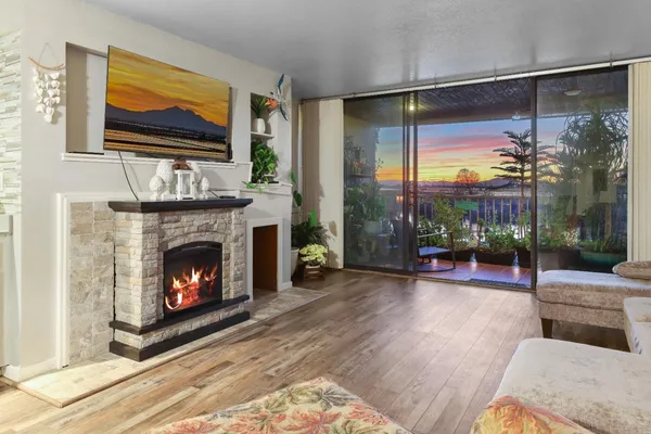 a living room with furniture a fireplace and a floor to ceiling window