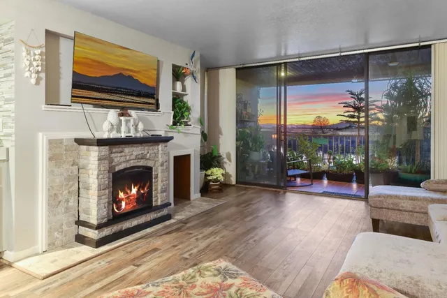 a living room with furniture a fireplace and a floor to ceiling window