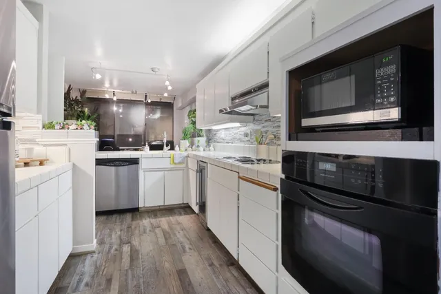 a kitchen with a sink stainless steel appliances and cabinets