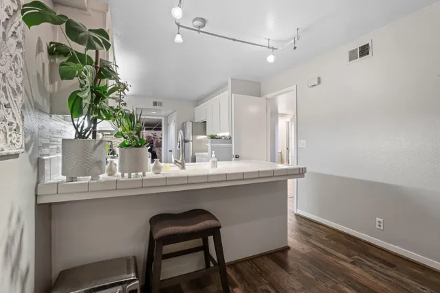 a dining room with table chairs and potted plant