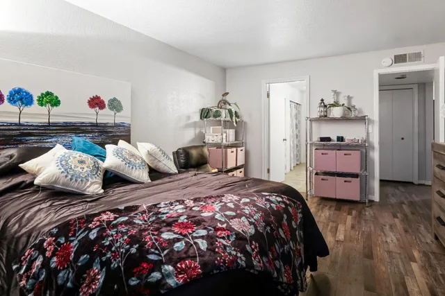 a bedroom with bed and wooden floor