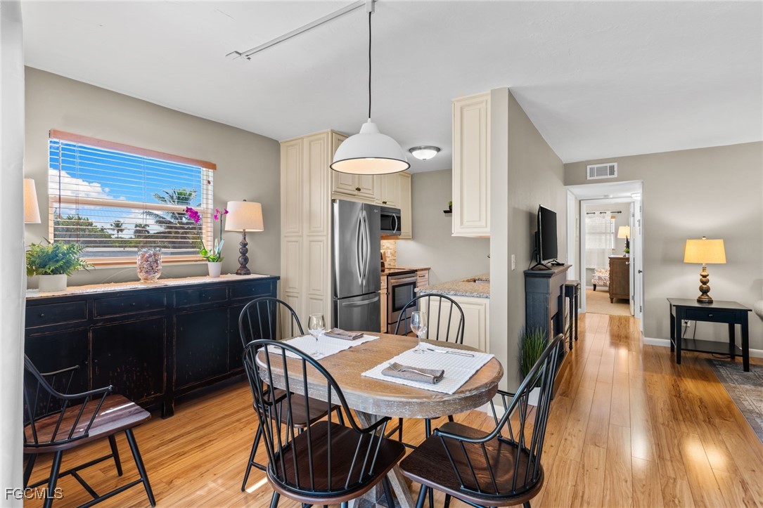601 Periwinkle Way, Unit C5 Sanibel, FL 33957 - Photo 16 of 35 a dining room with furniture a window and wooden floor