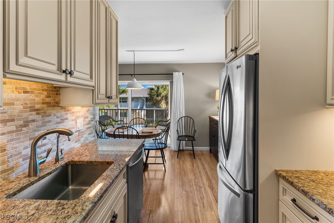 601 Periwinkle Way, Unit C5 Sanibel, FL 33957 - Photo 19 of 35 a kitchen with a refrigerator sink and cabinets