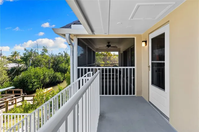a living room with furniture a ceiling fan a lamp and a window