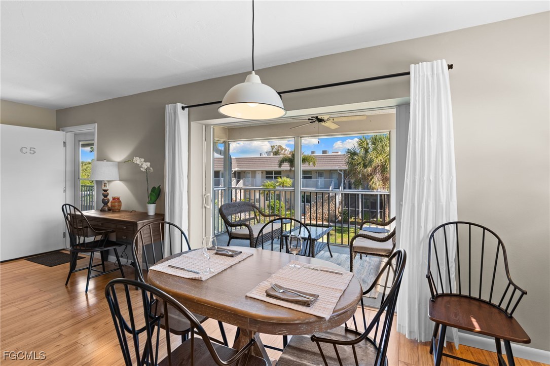 601 Periwinkle Way, Unit C5 Sanibel, FL 33957 - Photo 10 of 35 a dining room with furniture a chandelier and wooden floor