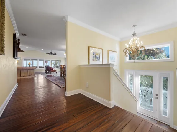 a kitchen with a sink dishwasher and white cabinets with wooden floor