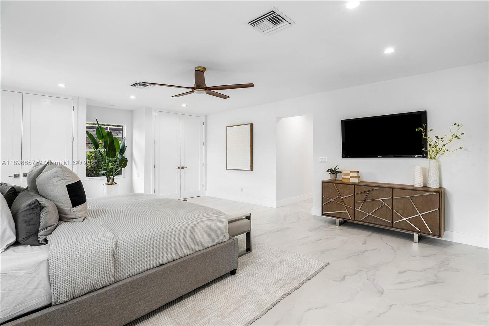 1338 Southwest 13th Street Boca Raton, FL 33486 - Photo 14 of 45 a bedroom with a bed a couch and a flat screen tv