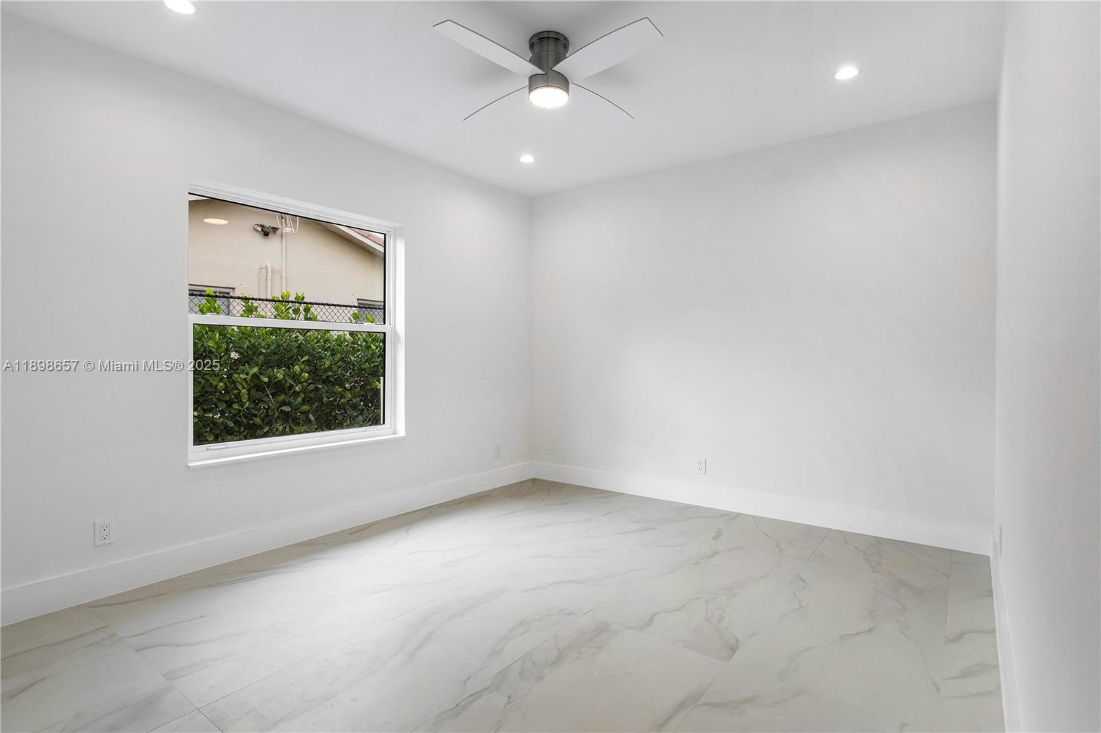 1338 Southwest 13th Street Boca Raton, FL 33486 - Photo 26 of 45 an empty room with a window and a ceiling fan