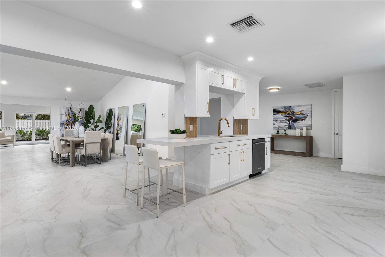 1338 Southwest 13th Street Boca Raton, FL 33486 - Photo 3 of 45 a large white kitchen with white cabinets and chairs