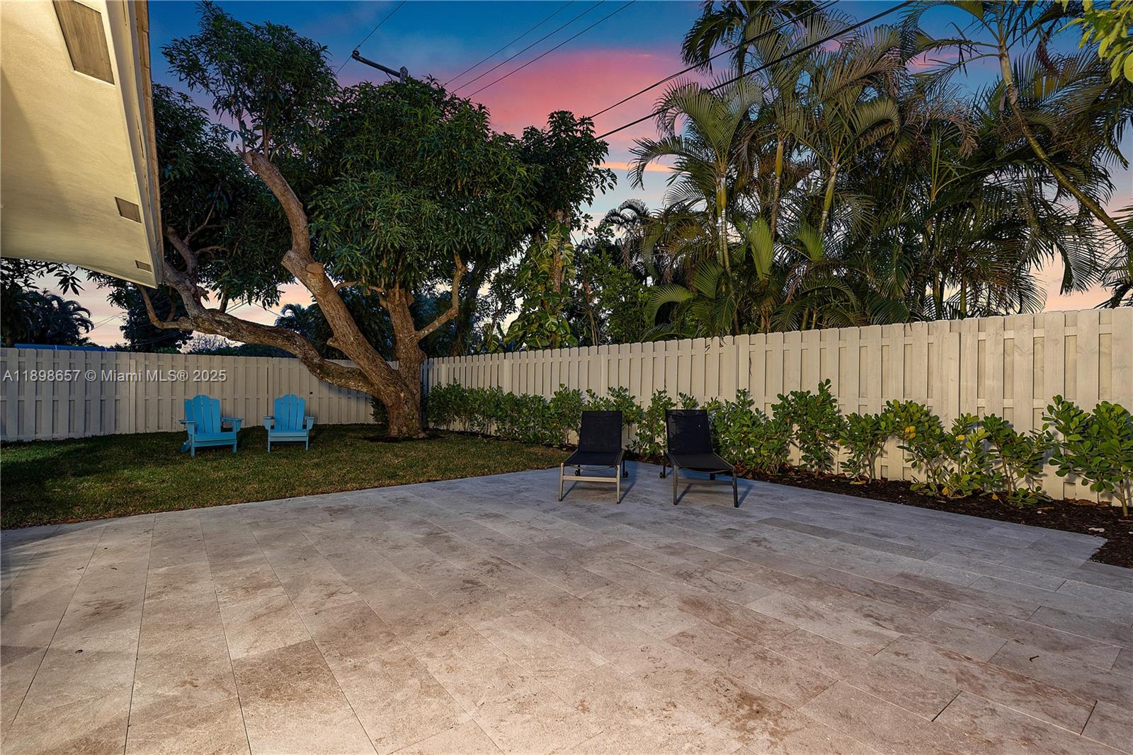 1338 Southwest 13th Street Boca Raton, FL 33486 - Photo 32 of 45 a view of a backyard with table and chairs and wooden fence
