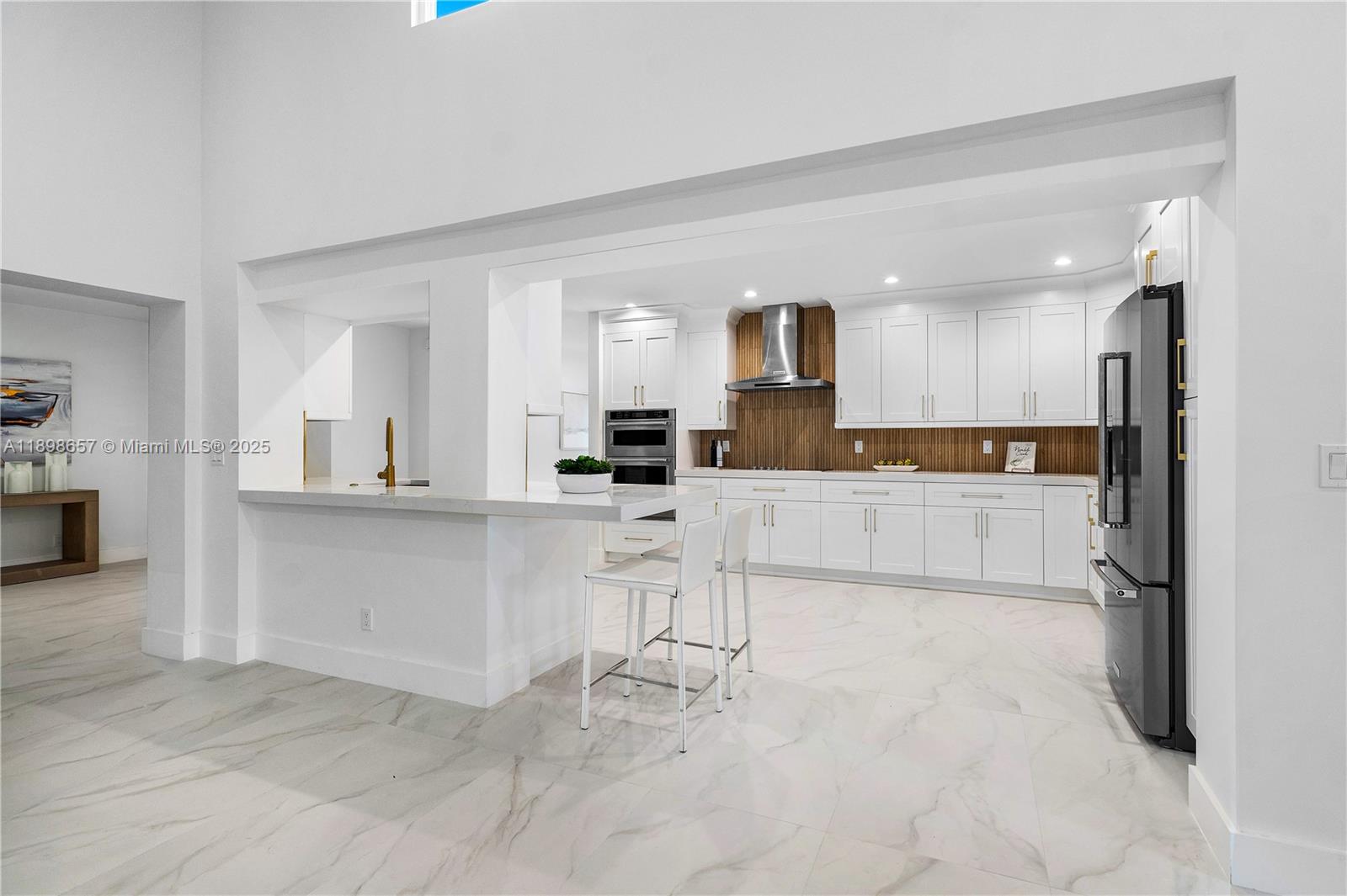 1338 Southwest 13th Street Boca Raton, FL 33486 - Photo 10 of 45 a kitchen with white cabinets and refrigerator