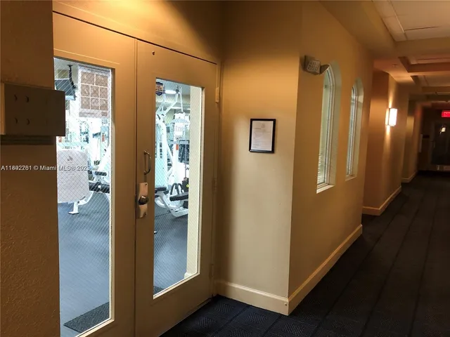a view of a hallway with wooden floor and a bathroom