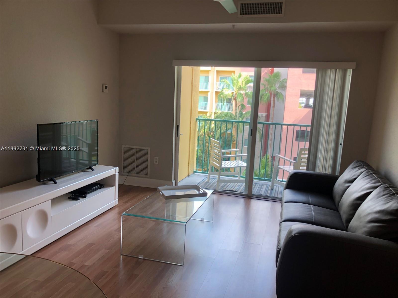 6001 Southwest 70th Street, Unit 528 South Miami, FL 33143 - Photo 5 of 21 a living room with furniture and a flat screen tv