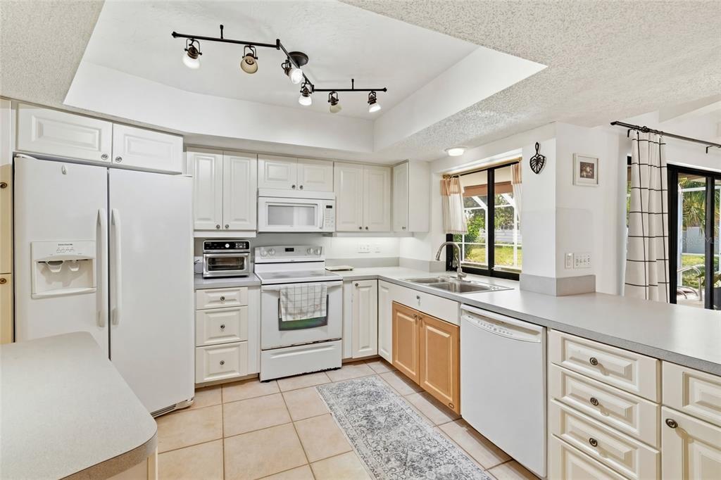 3927 Country View Lane Sarasota, FL 34233 - Photo 11 of 48 a kitchen with cabinets stainless steel appliances a sink and a counter top space