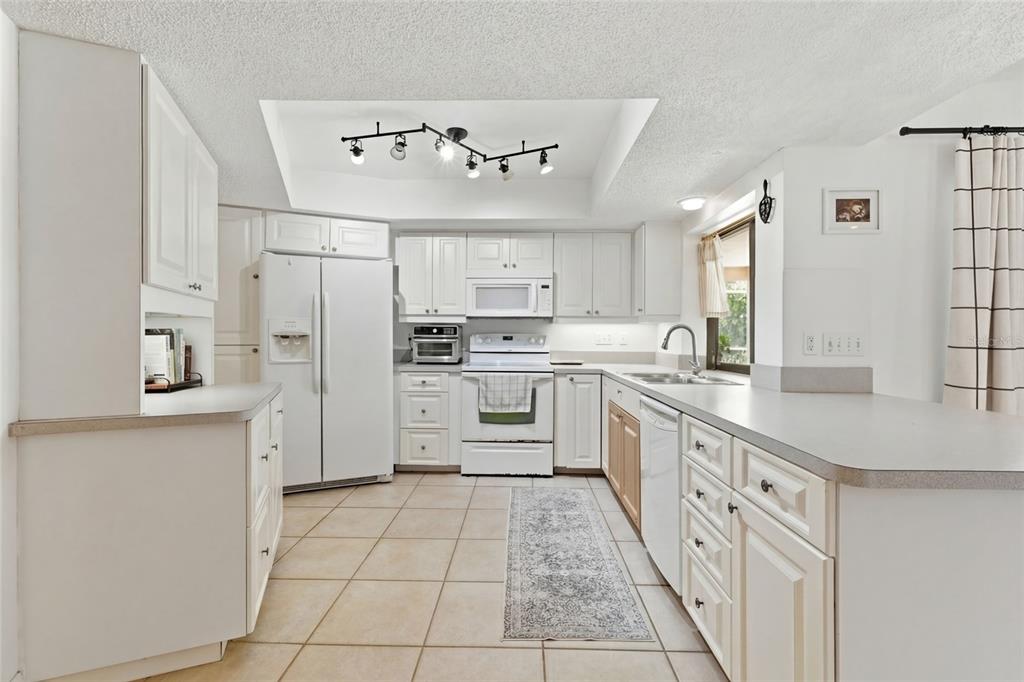 3927 Country View Lane Sarasota, FL 34233 - Photo 12 of 48 a large kitchen with cabinets and stainless steel appliances