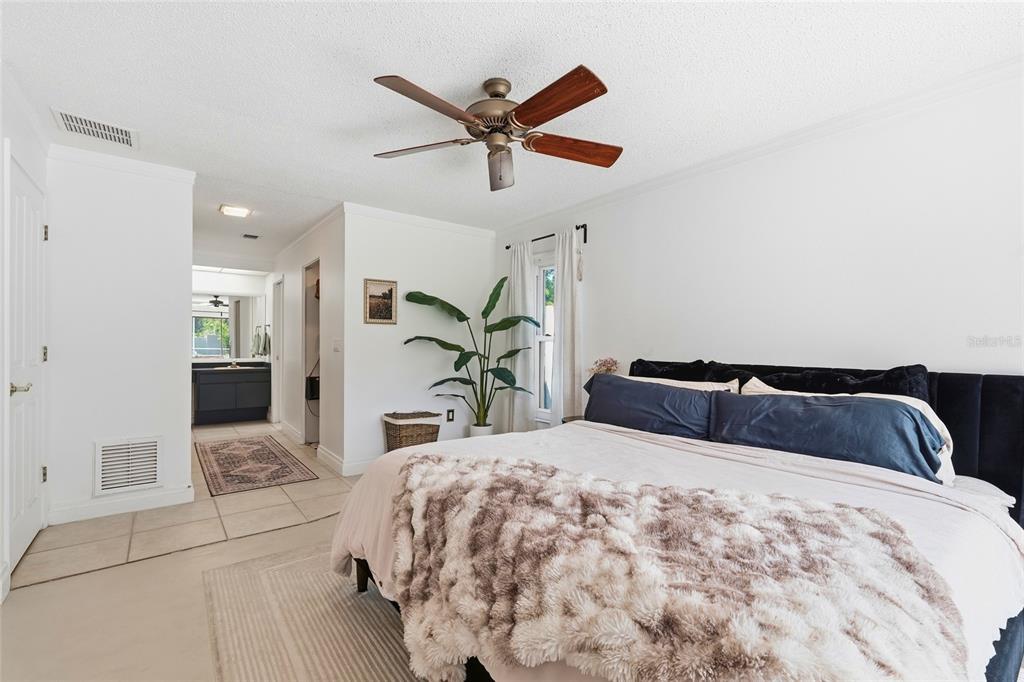 3927 Country View Lane Sarasota, FL 34233 - Photo 15 of 48 a bedroom with a large bed and a chandelier