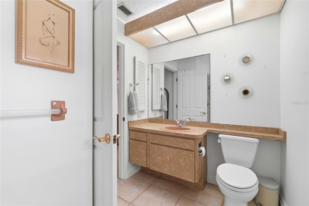3927 Country View Lane Sarasota, FL 34233 - Photo 36 of 48 a bathroom with a toilet sink vanity and mirror