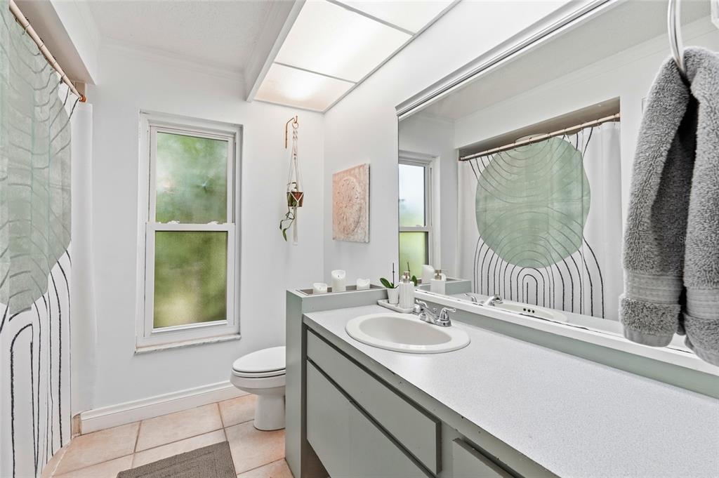 3927 Country View Lane Sarasota, FL 34233 - Photo 39 of 48 a bathroom with a sink a toilet a mirror and window