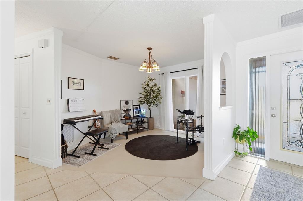 3927 Country View Lane Sarasota, FL 34233 - Photo 7 of 48 a living room with furniture a chandelier and a potted plant