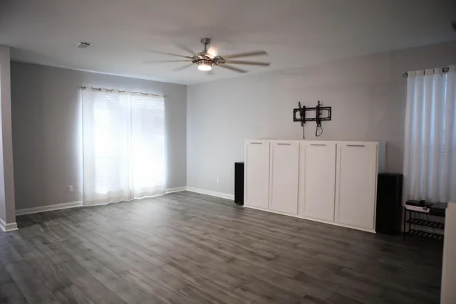 a view of a livingroom with a window and wooden floor