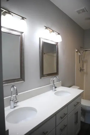 a bathroom with double vanity sinks and a mirror