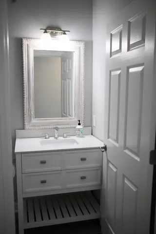 a bathroom with a granite countertop sink and a mirror