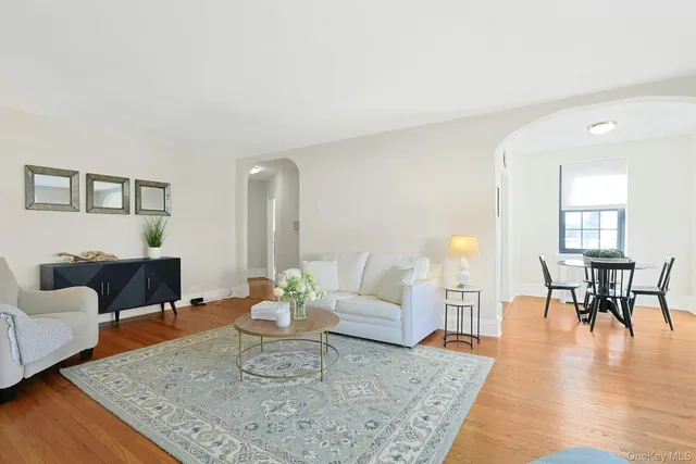 a living room with furniture wooden floor and a table