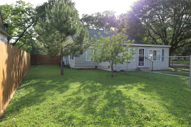 a front view of house with yard and trees in the background