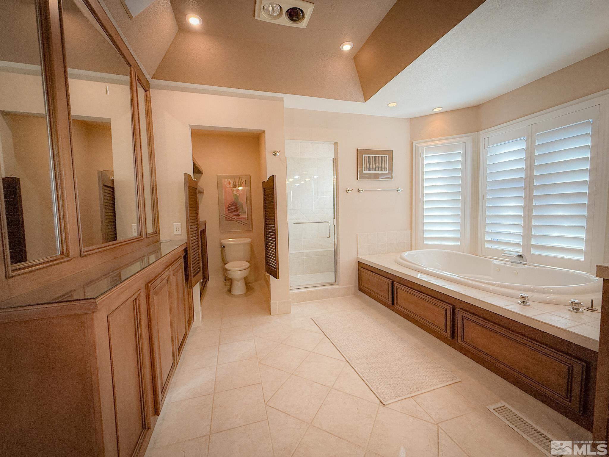 3775 Clover Way Reno, NV 89509 - Photo 18 of 40 a bathroom with a tub a double vanity sink and a large mirror next to a window