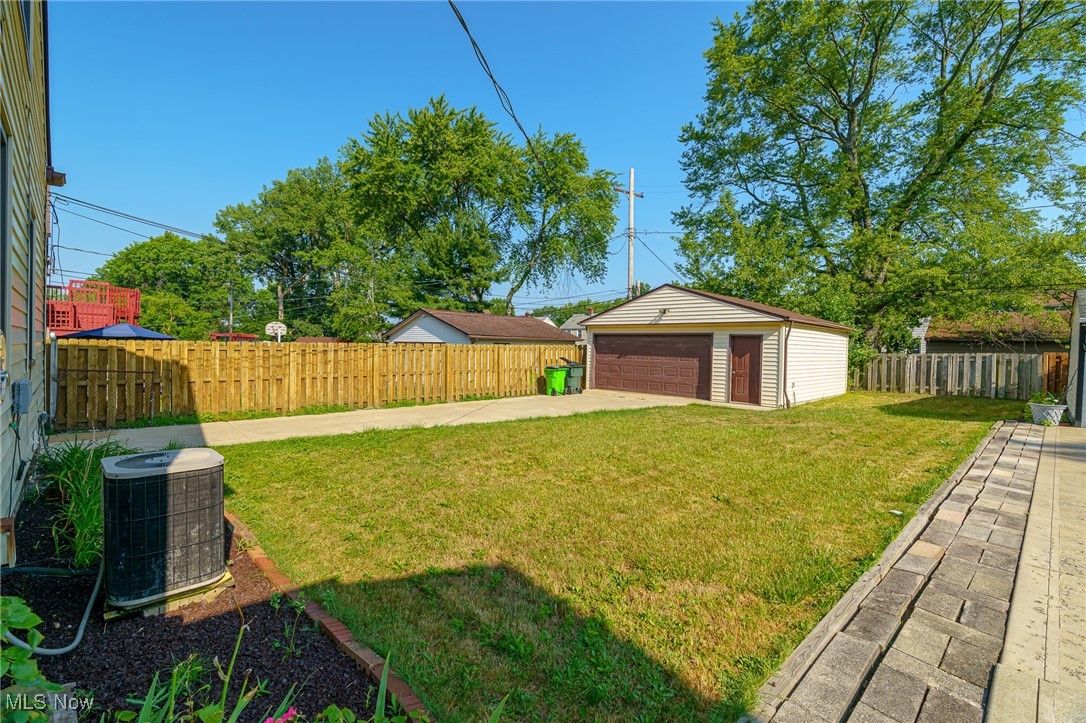 12727 Grannis Road Cleveland, OH 44125 - Photo 43 of 43 View of yard featuring cooling unit, a garage, and an outbuilding
