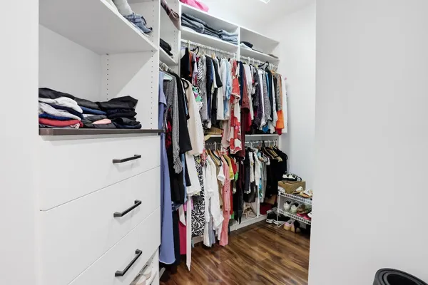 a view of walk in closet with clothes