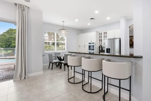 a dining room filled chandelier and kitchen view