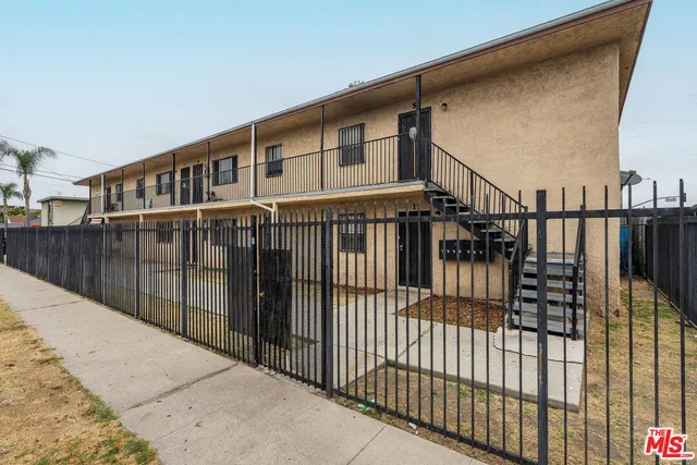 a view of a brick house with a wooden fence
