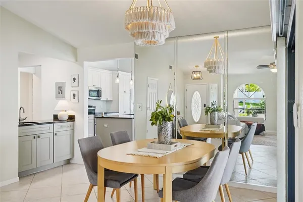a living room with furniture kitchen view and a chandelier