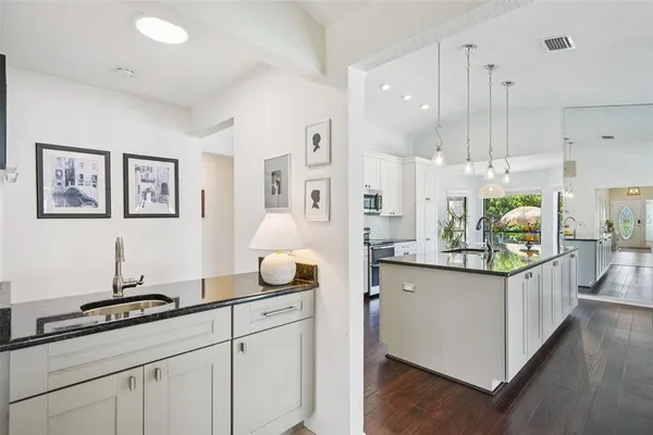 a kitchen with white cabinets and appliances